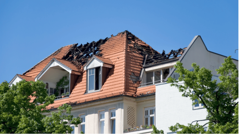 Et hus som har et ødelagt tak etter brann